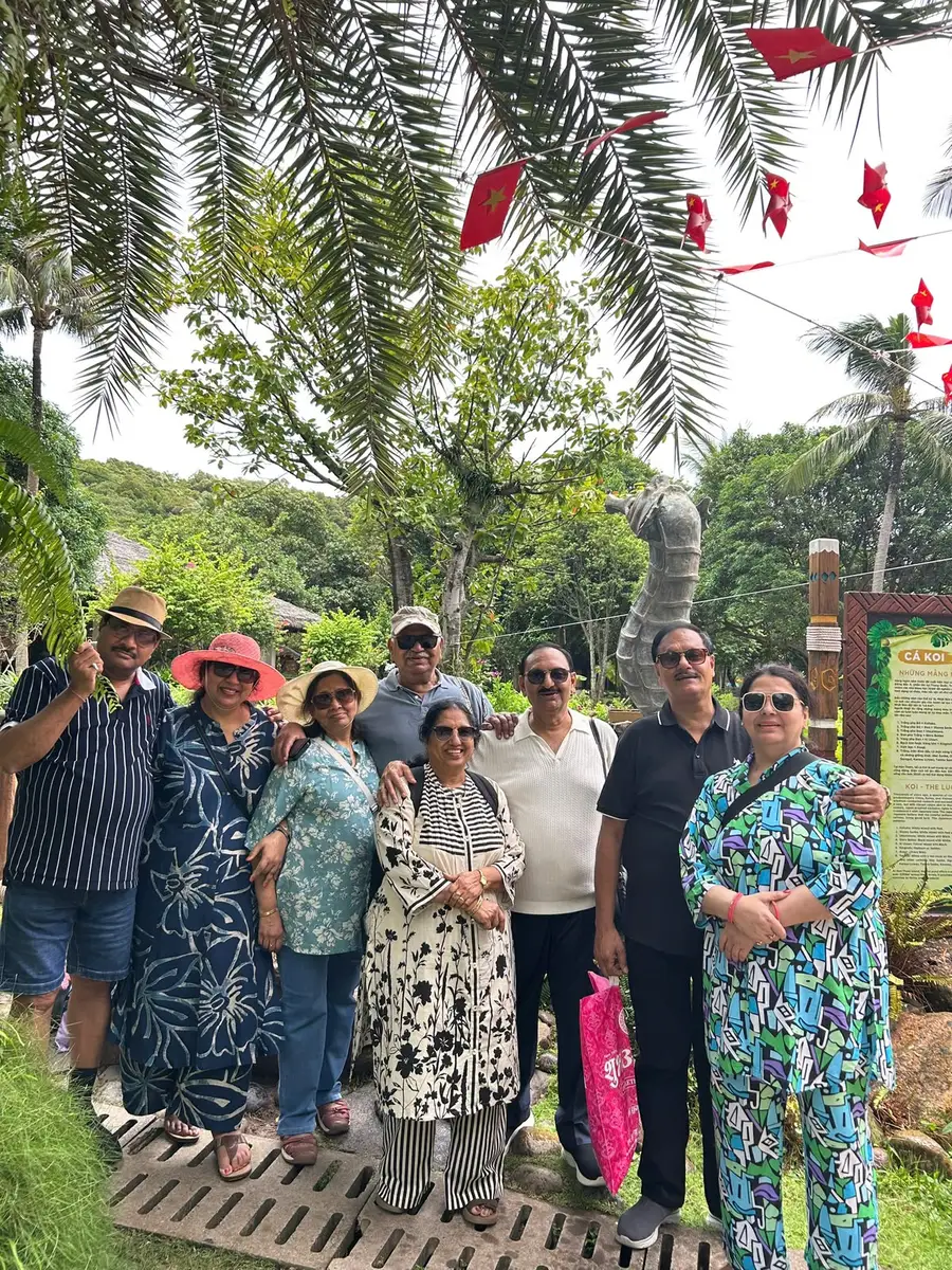 A travelling party standing together under the palms on a garden walkway in Vietnam