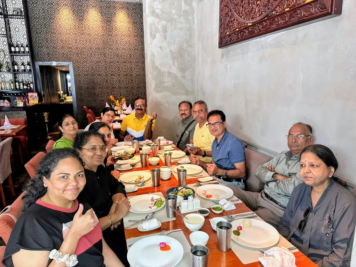 A travelling party seated along a long table over an Indian meal arranged for them at a restaurant in Vietnam