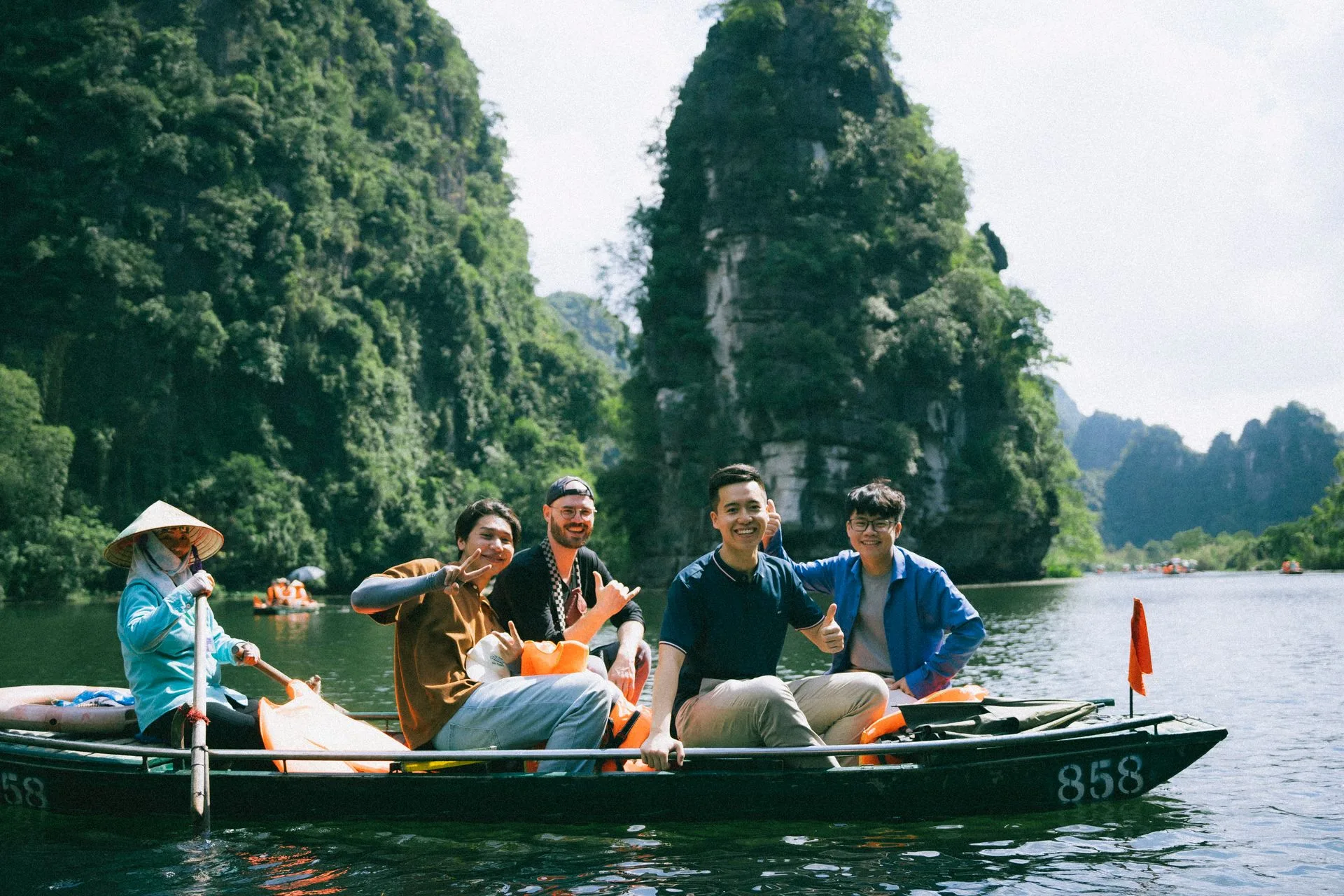 A Fiesta Asia Travel group on a sampan among the limestone karsts of Ninh Binh, Vietnam