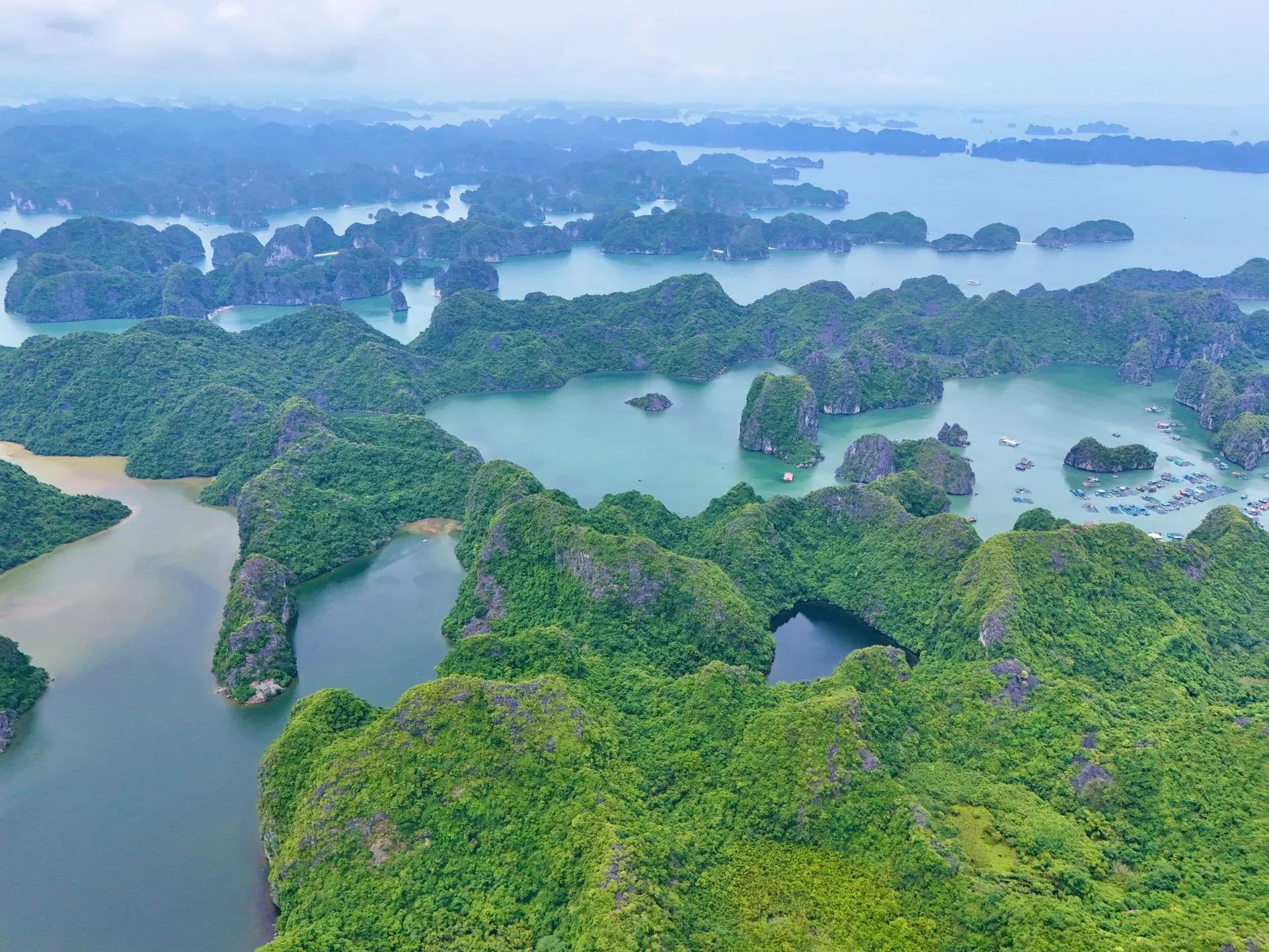 Limestone karsts and a floating fishing village across a Vietnamese bay — Vietnam DMC