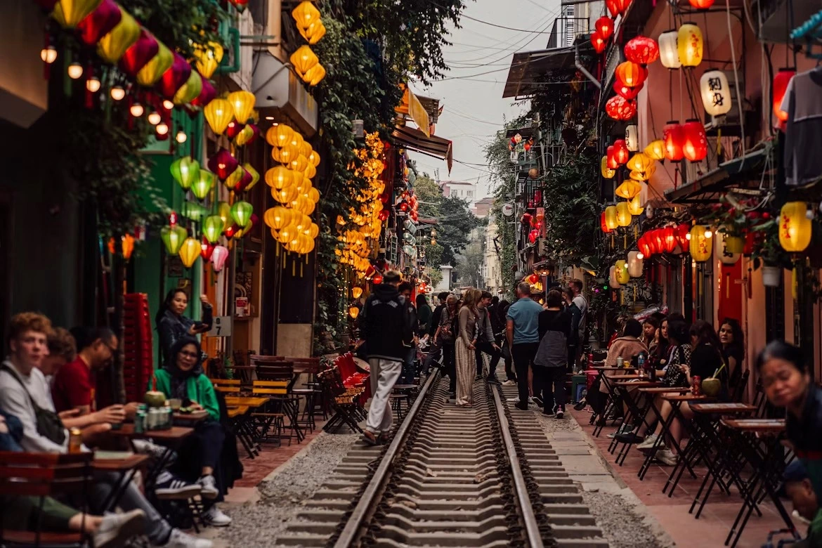 Lantern-strung tables and shopfronts lining the tracks of Hanoi Train Street