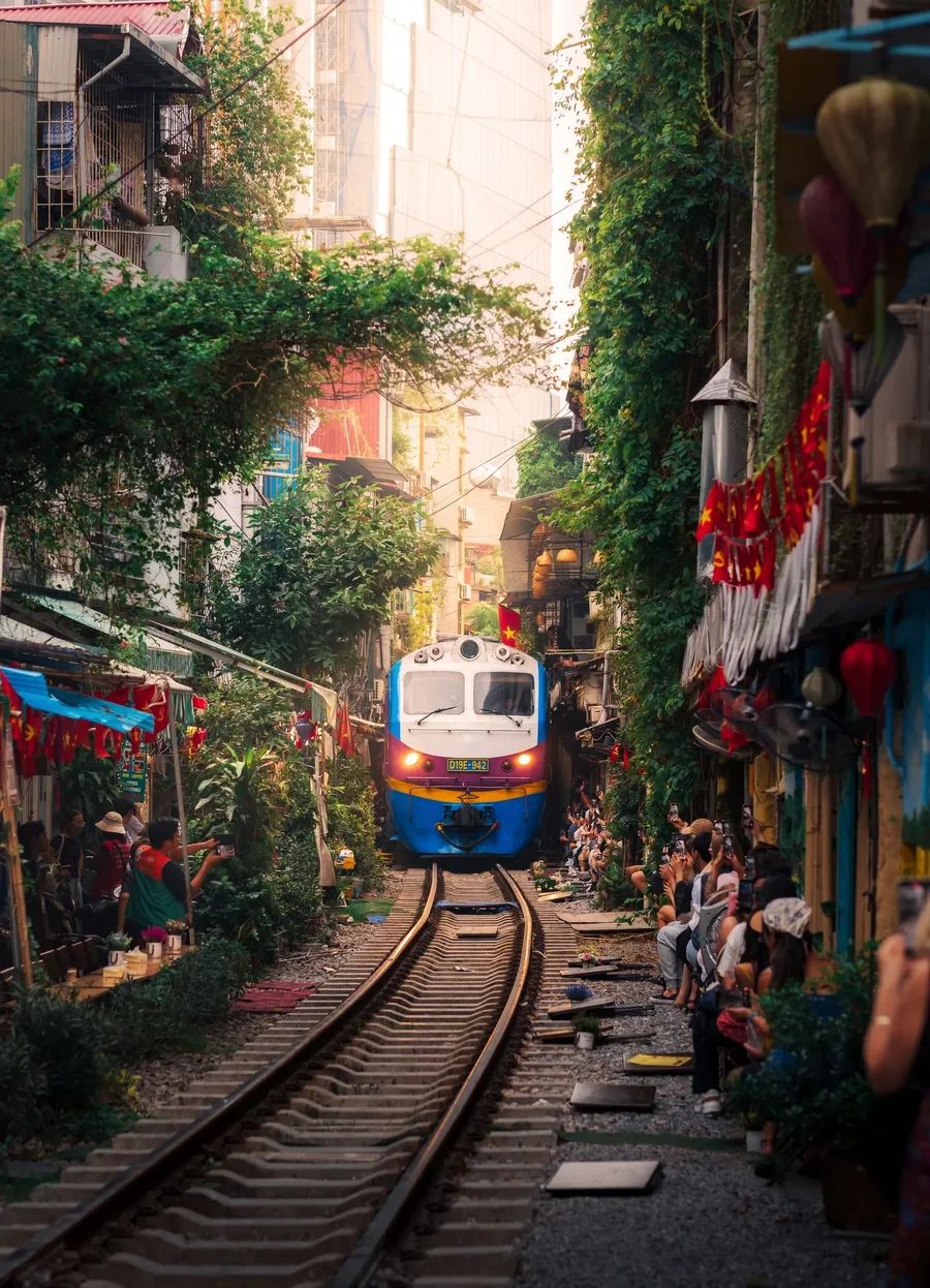 A train passing between the houses of Hanoi Train Street — Vietnam DMC by Fiesta Asia Travel