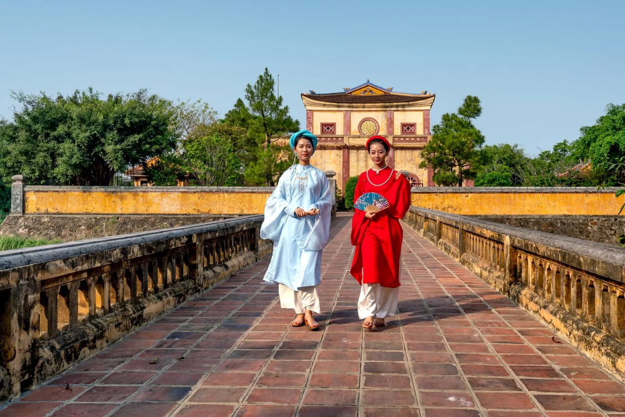 Traditional ao dai at a gate within Hue’s Imperial City