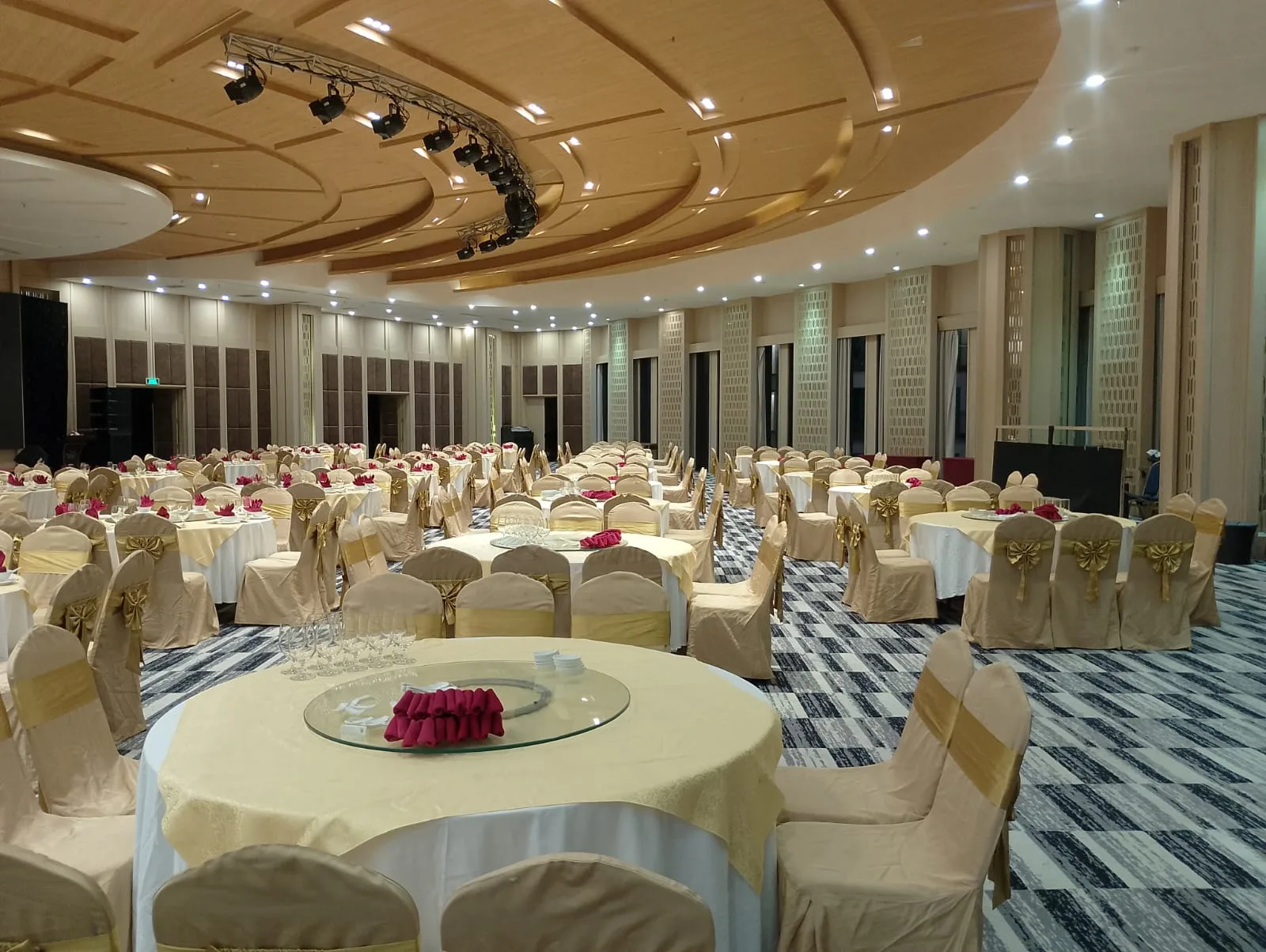 A gala dinner ballroom set with round tables and gold chair sashes, ready before delegates arrive