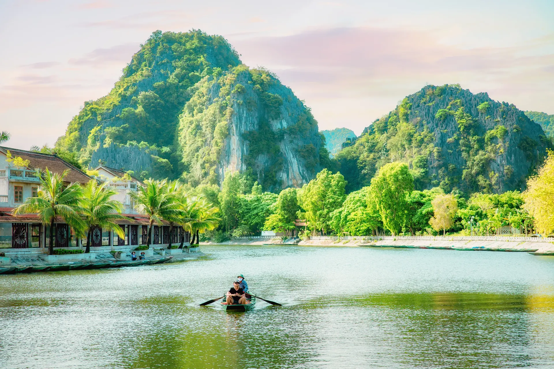 Paddling a small boat between towering karst cliffs and caves