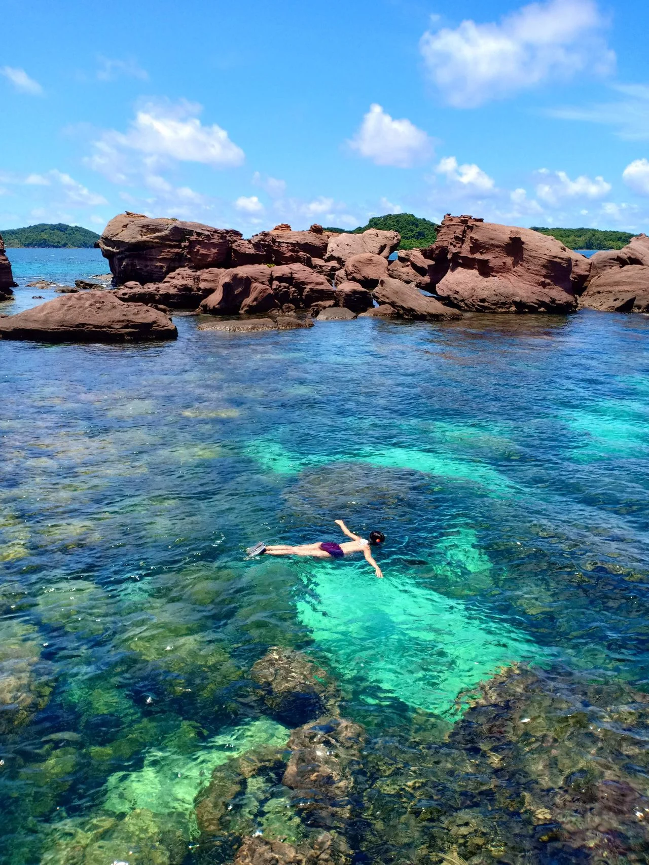 Swimming in clear turquoise water beside karst islands