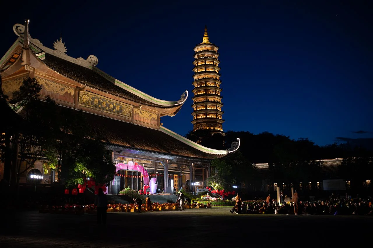 A multi-tiered pagoda tower lit up at night near Hue
